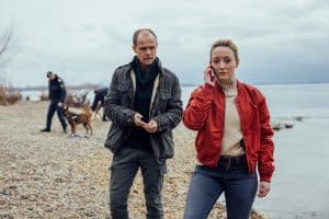 "Die Toten vom Bodensee - Die Medusa": Micha Oberländer (Matthias Koeberlin) und Luisa Hoffmann (Alina Fritsch) stehen zusammen am Ufer. Luisa Hoffmann (Alina Fritsch) telefoniert mit dem Handy.