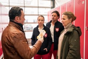 "Die Chefin - Grenzgänger": Paul Böhmer (Jürgen Tonkel) hält mehrere 200 Euro Scheine in der Hand. Die Rettungssanitäter Sebastian Weber (Stephan Luca) und Martina Jessing (Anna Brüggemann) blicken ihn skeptisch an. Vera Lanz (Katharina Böhm) steht neben ihm im Spindbereich der Rettungsstation.