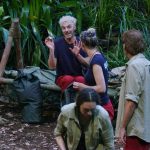 Sam Dylan sitzt auf einer Holzbank im Camp und hält ein abgebrochenes Stück seiner Make-up-Palette in der Hand. Er verteidigt sich gestikulierend gegenüber den anderen Camp-Bewohnern und beteuert, dass es sich um ein Versehen handelt. Skeptische Blicke zeigen jedoch, dass ihm nicht alle glauben. Die Diskussion um die Schmuggelware sorgt für Spannungen in der Gruppe.