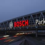 Nachtaufnahme des Bosch-Parkhauses, das mit einem großen leuchtenden Schriftzug über der A8 thront.
