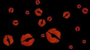 Mehrere rote Kussmund-Abdrücke unterschiedlicher Größe auf schwarzem Hintergrund, verteilt in einem zufälligen Muster. Die Kussmünder wirken stilisiert und erinnern an ein verspieltes, grafisches Design.