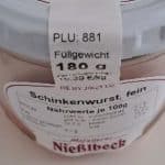 Ein Glas Schinkenwurst der Marke Metzgerei Nießlbeck. Auf dem Etikett sind Produktdetails wie die PLU 881, ein Füllgewicht von 180 Gramm und das Mindesthaltbarkeitsdatum 28.12.2025 zu sehen.