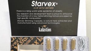 Verpackung des Schlankheitsmittels „Starvex“ mit geöffnetem Karton und einer Blisterpackung, die teils leere und teils gefüllte Kapseln enthält. Auf der Verpackung stehen Werbeaussagen wie „Slim with Nature“ und Hinweise auf eine angeblich natürliche, pflanzliche Formel.
