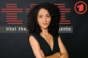 Moderatorin Siham El-Maimouni steht mit verschränkten Armen vor dem Logo der ARD-Kultursendung „ttt – titel thesen temperamente“. Sie trägt ein schwarzes ärmelloses Oberteil, hat dunkle, lockige Haare und blickt selbstbewusst in die Kamera. Im Hintergrund sind das rote „ttt“-Design und das ARD-Logo zu sehen.