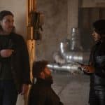 "Annika – Mord an Schottlands Küste - Annikas Vater": DS Michael McAndrews (Jamie Sives) und DC Harper Weston (Varada Sethu) stehen in einem großen, fast leeren Raum. Zwischen ihnen sitzt ein Mann (Komparse) auf dem Boden. Im Hintergrund liegen Rohre.