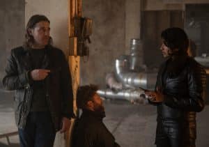 "Annika – Mord an Schottlands Küste - Annikas Vater": DS Michael McAndrews (Jamie Sives) und DC Harper Weston (Varada Sethu) stehen in einem großen, fast leeren Raum. Zwischen ihnen sitzt ein Mann (Komparse) auf dem Boden. Im Hintergrund liegen Rohre.