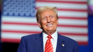 "Donald Trump - Rückkehr an die Macht": Vor der amerikanischen Flagge lächelt Trump in die Kamera.