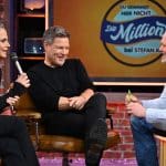Barbara Schöneberger, Robert Habeck und Stefan Raab in der Show Du gewinnst hier nicht die Million bei Stefan Raab. Schöneberger hält ein Mikrofon, während Habeck lacht und Raab mit einem Stift in der Hand spricht. Im Hintergrund das Show-Logo.