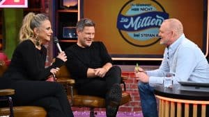 Barbara Schöneberger, Robert Habeck und Stefan Raab in der Show Du gewinnst hier nicht die Million bei Stefan Raab. Schöneberger hält ein Mikrofon, während Habeck lacht und Raab mit einem Stift in der Hand spricht. Im Hintergrund das Show-Logo.