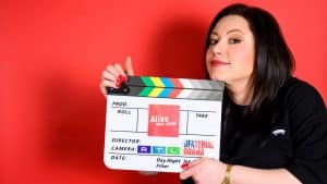 Julia Augustin hält eine Filmklappe in der Hand