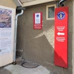 Eingang zur Spreuerhofstraße, der engsten Straße der Welt in Reutlingen. Eine rote Hinweistafel mit dem Guinness-World-Records-Logo weist den Weg. Daneben informiert eine Tafel über die Geschichte der Gasse.