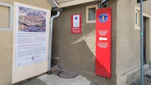Eingang zur Spreuerhofstraße, der engsten Straße der Welt in Reutlingen. Eine rote Hinweistafel mit dem Guinness-World-Records-Logo weist den Weg. Daneben informiert eine Tafel über die Geschichte der Gasse.