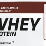 Eine Packung des Decathlon Whey Proteinpulvers mit Schokoladengeschmack (30 g). Die Verpackung ist überwiegend weiß mit braunen Akzenten und zeigt ein Abbild des Kakaopulvers. Auf der Vorderseite sind Informationen wie "21 g Whey-Protein pro 30 g", "Mit Stevia-Blattextrakt" und das Fairtrade-Logo zu sehen.