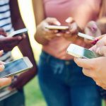 Gruppe hält die Smartphones in die Mitte