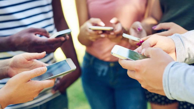 Gruppe hält die Smartphones in die Mitte