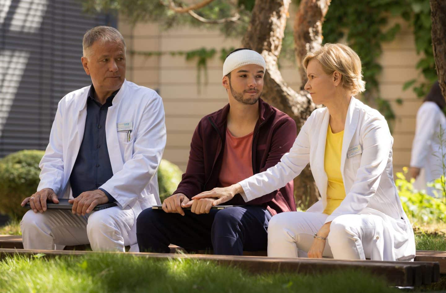 „In aller Freundschaft“: Zwei neue Folgen heute – Not-OP und dramatische Enthüllung! 2 Dr. Roland Heilmann (Thomas Rühmann, li.) lässt sich von seinem Enkel Jonas (Anthony Petrifke, mi.), dem es schon viel besser geht, mit den Tondateien für seinen Podcast helfen. Doch Rolands Frau Dr. Kathrin Globisch (Andrea Kathrin Loewig, re.) ist der Meinung, dass Jonas noch etwas Ruhe braucht und unterbindet die Lehrstunde.