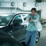 "Mord im Mittsommer - Madeleine": Welpe (Julius Fleischanderl) steht in einem Parkhaus vor einem Auto. Er hält seine Pistole in beiden Händen und richtet sie auf ein Ziel.