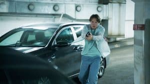 "Mord im Mittsommer - Madeleine": Welpe (Julius Fleischanderl) steht in einem Parkhaus vor einem Auto. Er hält seine Pistole in beiden Händen und richtet sie auf ein Ziel.