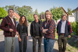 "SOKO Leipzig - Hasch mich": Kim (Amy Mußul), Jan (Marco Girnth), Wolfgang Güntgen (Michael Benthin) und Silke Wegener (Annedore Kleist) stehen in einem gepflegten Wohngebiet auf einer Straße. Jimmy Niehaus (Michael Kranz) steht mit beunruhigtem Blick neben der Gruppe.