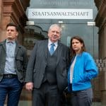 "Der Staatsanwalt - Tödliche Nähe": Bernd Reuther (Rainer Hunold) steht mit Julia Schröder (Anika Baumann) und Alexander Witte (Jannik Mioducki) vor einer großen Glastür. Über der Tür steht in großer Schrift "Staatsanwaltschaft".