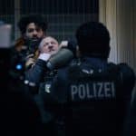 "Nachtschicht - Der Unfall": Joon Rostami (Altamasch Noor) bedroht Roland Orbach (Maximilian Brückner) mit einer Waffe. Jalil (Aziz Dyab) steht mit gezogener Waffe vor Ihnen.