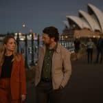 "North Shore – Tod in Sydney – Sophies Laptop": Es ist Abend. Abigail (Joanne Froggatt) und Simon (Dan Spielman) gehen im Freien nebeneinander her. Im Hintergrund liegt das Opernhaus von Sydney.