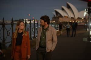 "North Shore – Tod in Sydney – Sophies Laptop": Es ist Abend. Abigail (Joanne Froggatt) und Simon (Dan Spielman) gehen im Freien nebeneinander her. Im Hintergrund liegt das Opernhaus von Sydney.