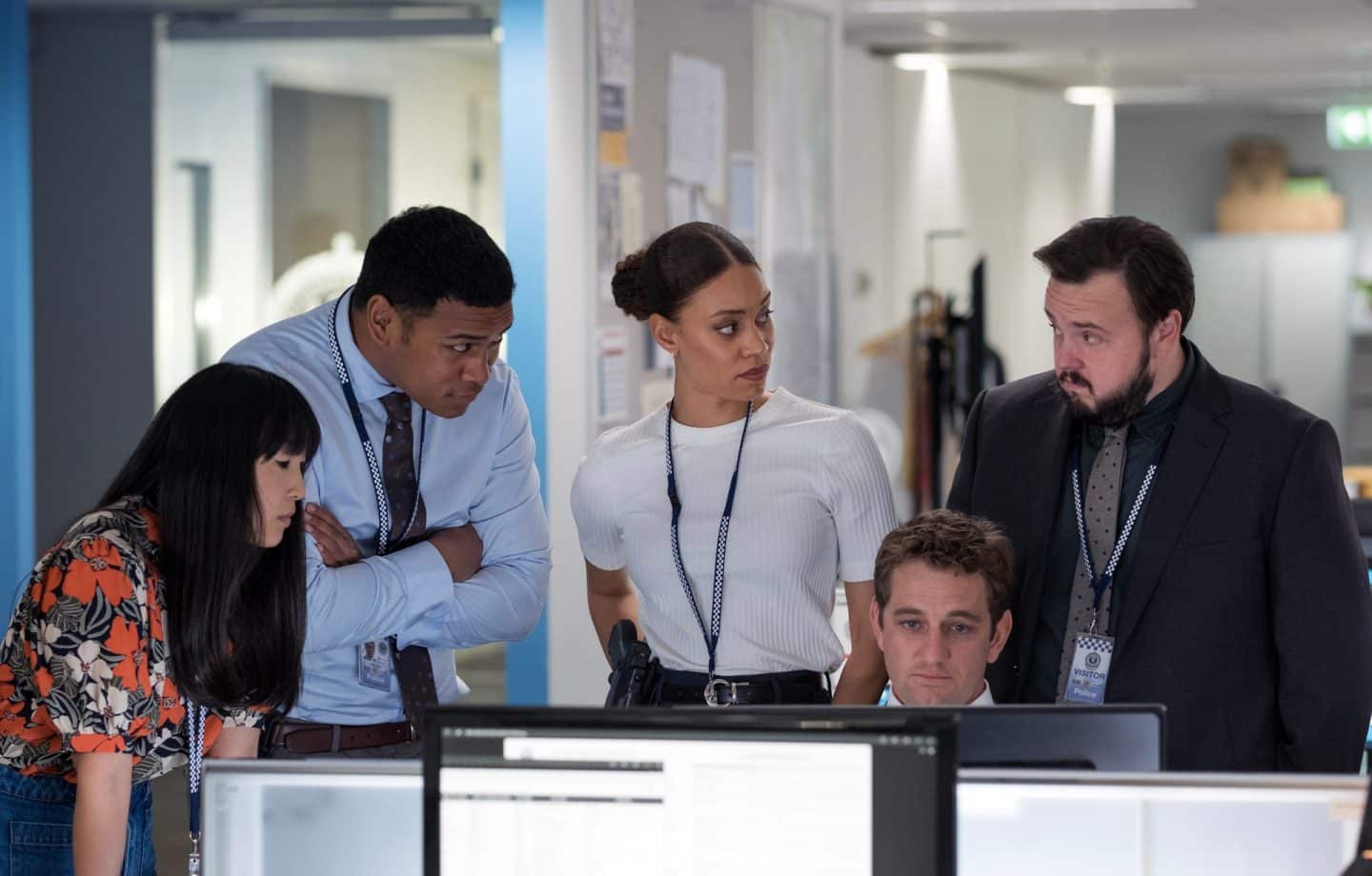"North Shore – Tod in Sydney – Termingeschäfte": DC Lachie Hooper (Dylan Hare) sitzt an seinem Schreibtisch vor einem Computerbildschirm. PC Cindy Yoo (Cassandra Sorrell), DC Paea Leniu (Chris Alosio), DS Meg Driscoll (Kirsty Sturgess) und DS Max Drummond (John Bradley) stehen um ihn herum.
