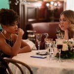 "The Man From Toronto": Lori (Jasmine Mathews) sitzt nachdenklich an einem Tisch in einem Restaurant. Anne (Kaley Cuoco) sitzt neben ihr und schaut sie erwartungsvoll an.
