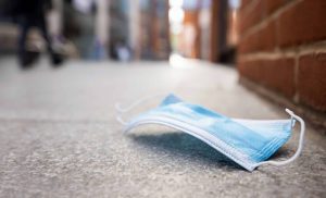 Eine OP-Maske liegt auf dem Boden