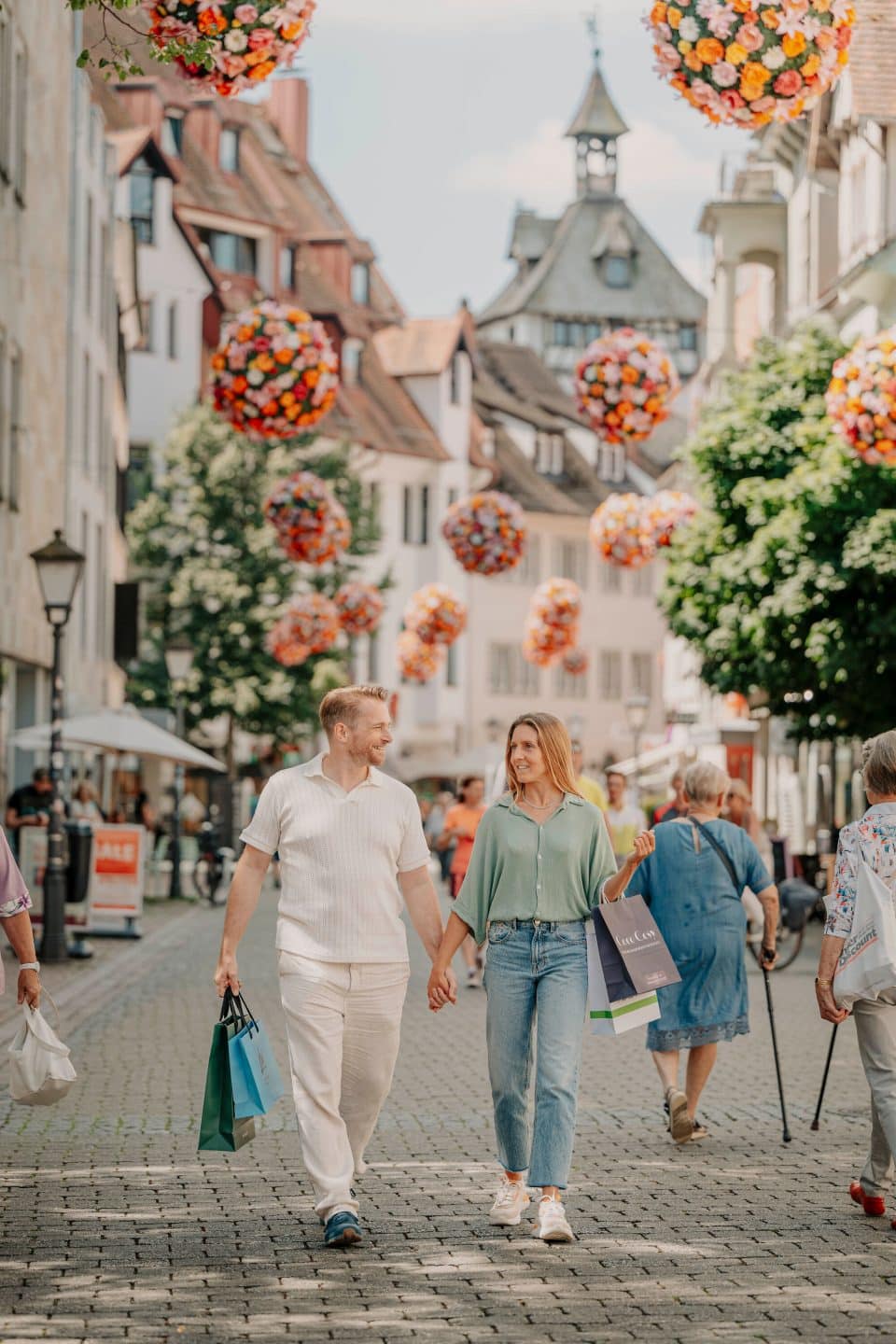 Frühling 2025: Die Konstanzer Altstadt blüht auf – und das im wahrsten Sinne des Wortes Konstanz Altstadt Hussenstrasse Schnetztor Flowerball Einkaufen Paar 06 Copyright MTK Leo L