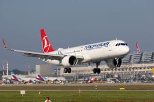 Ein Flugzeug von Turkish Airlines landet am Flughafen Stuttgart, im Hintergrund sind Flugzeuge von Eurowings und das Flughafenterminal zu sehen.