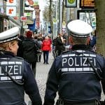 Rückenansicht von 2 Polizisten die in´m Stadtinnern auf Fußstreife sind.