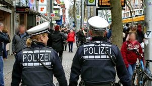 Rückenansicht von 2 Polizisten die in´m Stadtinnern auf Fußstreife sind.