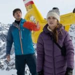 "Die Bergretter: Eiskalte Wahrheit (1)": Der Rettungshubschrauber steht vor einer schneebedeckten Bergkette. Davor steht Lisa (Lena Meckel) mit ernstem Gesichtsausdruck abgewandt von Daniel (Julian Felix). Dieser hebt hinter ihr seine Hand als Geste des Streits.