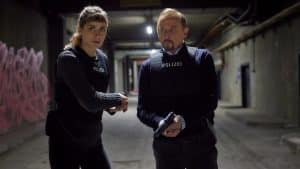 "Stralsund - Der letzte Sieg": Jule Zabek (Sophie Pfennigstorf) und Karl Hidde (Alexander Held) stehen mit gezogenen Waffen und schusssicheren Westen im Tunnelsystem.