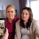 "Lena Lorenz - Vor aller Augen": In einem Krankenzimmer sitzen Lena Lorenz (Judith Hoersch) und Nadja Brettschneider (Vivien König) nebeneinander auf einem Bett. Beide schauen in eine Handykamera, die auf sie gerichtet wird.