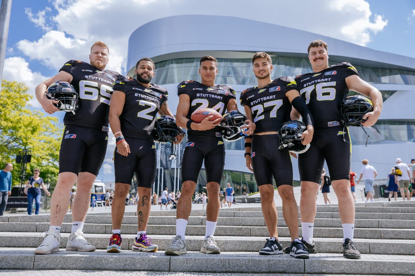 Spieler der Stuttgart Surge posieren in Football-Ausrüstung vor dem Mercedes-Benz Museum in Stuttgart vor dem ELF-Finale 2025.
