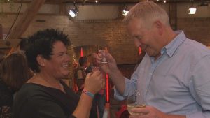 Simone und Jörg stoßen beim Finale von „Bauer sucht Frau“ lachend mit einem Schnapsglas und einem Weinglas an.