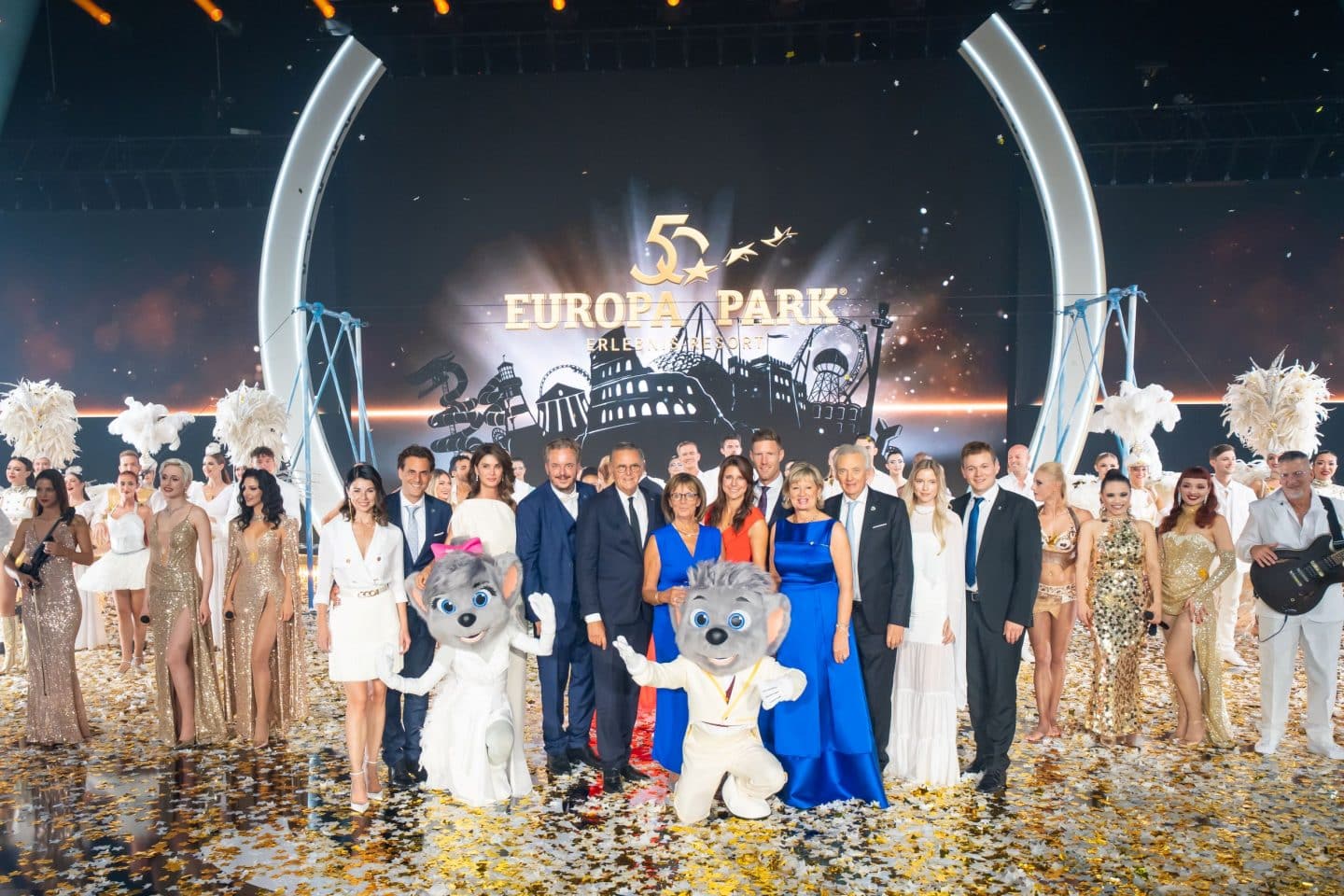 Die Inhaberfamilie Mack gemeinsam mit Künstlern und Maskottchen auf der Bühne zum Finale der 50-Jahre-Gala des Europa-Parks, umgeben von Konfetti und Bühnenbeleuchtung.