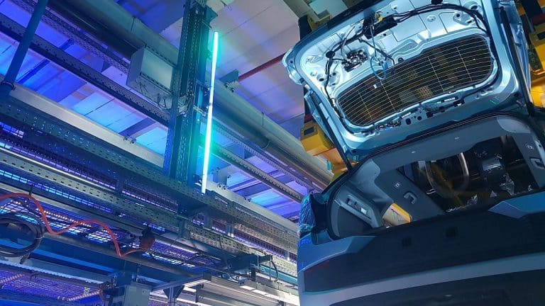 Blick auf ein offenes Auto mit futuristischer Beleuchtung in einer Werkstatt.