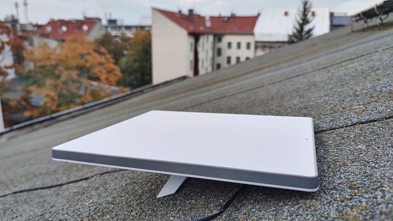 Weiße Antenne auf einem Dach mit städtischem Hintergrund.