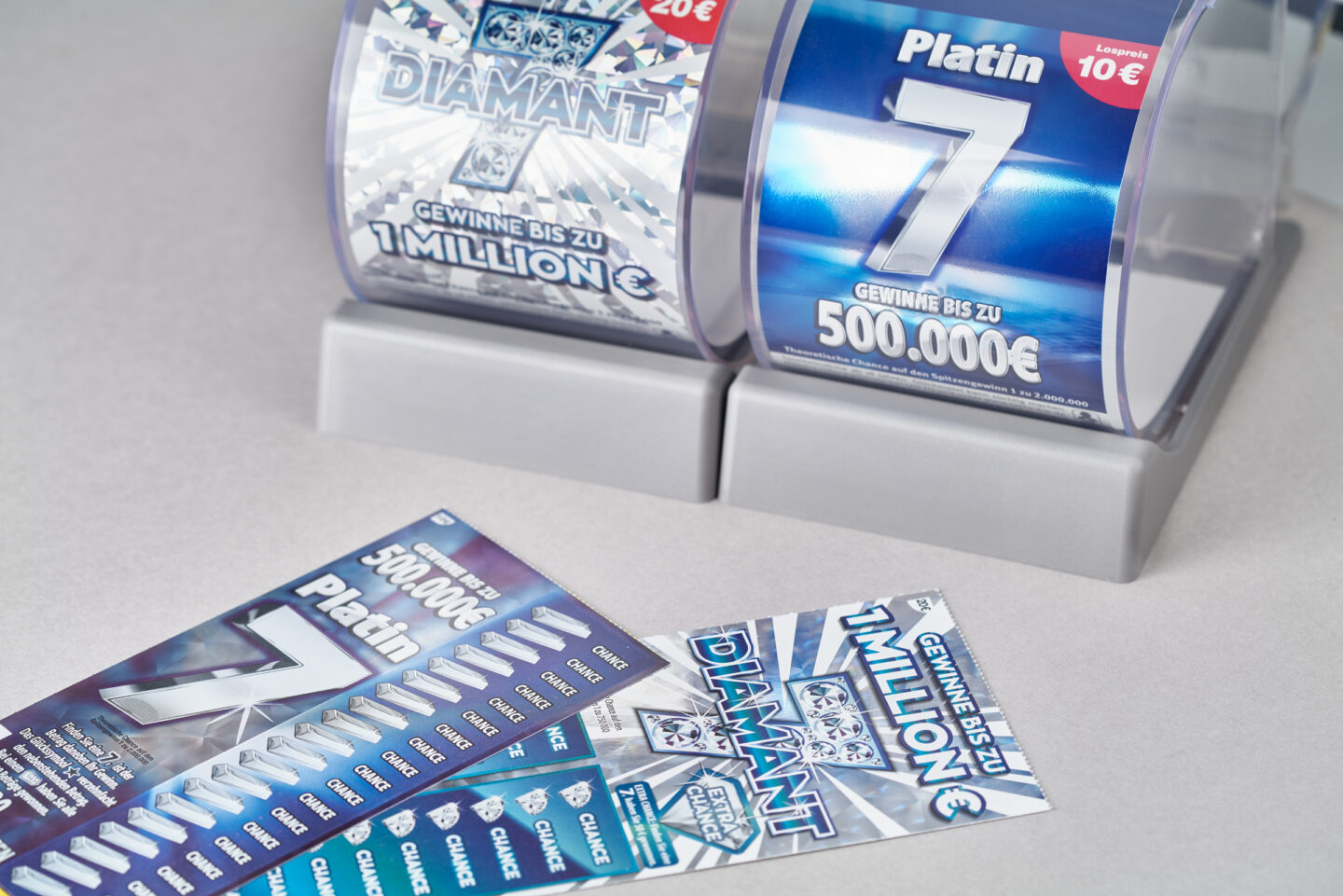 Zwei Lotterietrommeln und mehrere Rubbellose auf einem Tisch.