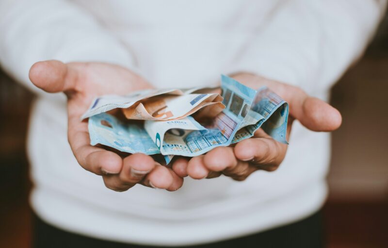 Hände halten zerknitterte Euro-Banknoten