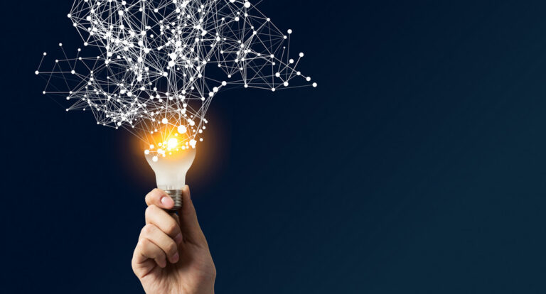Hand hält eine leuchtende Glühbirne als Symbol für Forschung und Innovation