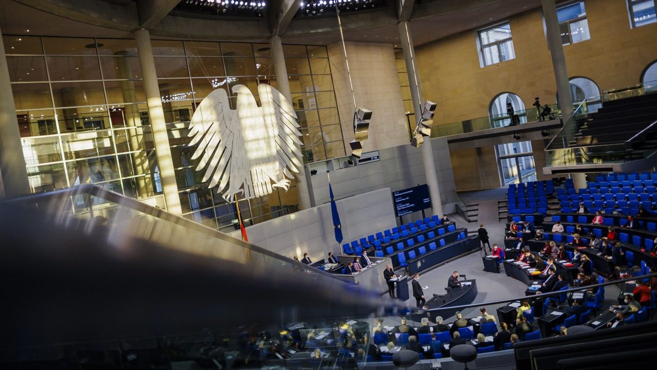 Die tief stehende Sonne beleuchtet den Plenarsaal. Blick auf den Bundestagsadler. Blick ins Plenum.