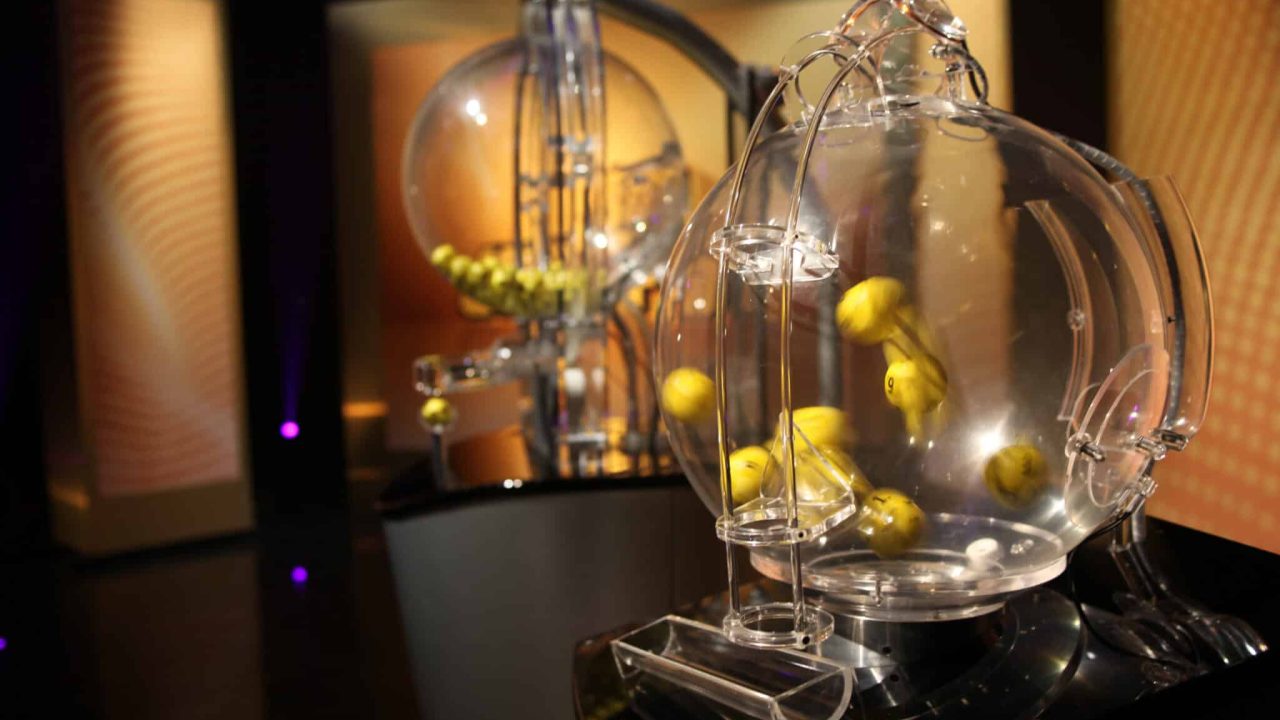 Transparente Lotteriekugeln mit gelben Bällen in einem modernen Setting.