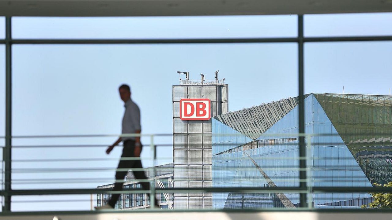 Mann geht an einem Gebäude mit DB-Logo vorbei.