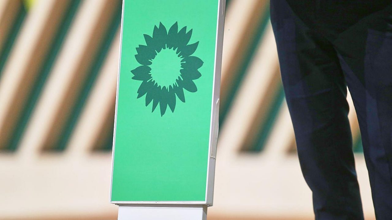 Grünes Schild mit Sonnenblumen-Logo, Teil eines Events.