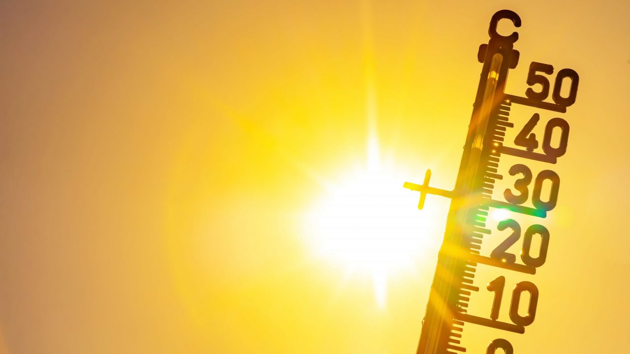 Hot weather - Heat wave / Summer heat background - Thermometer yellow orange sky and sun rays